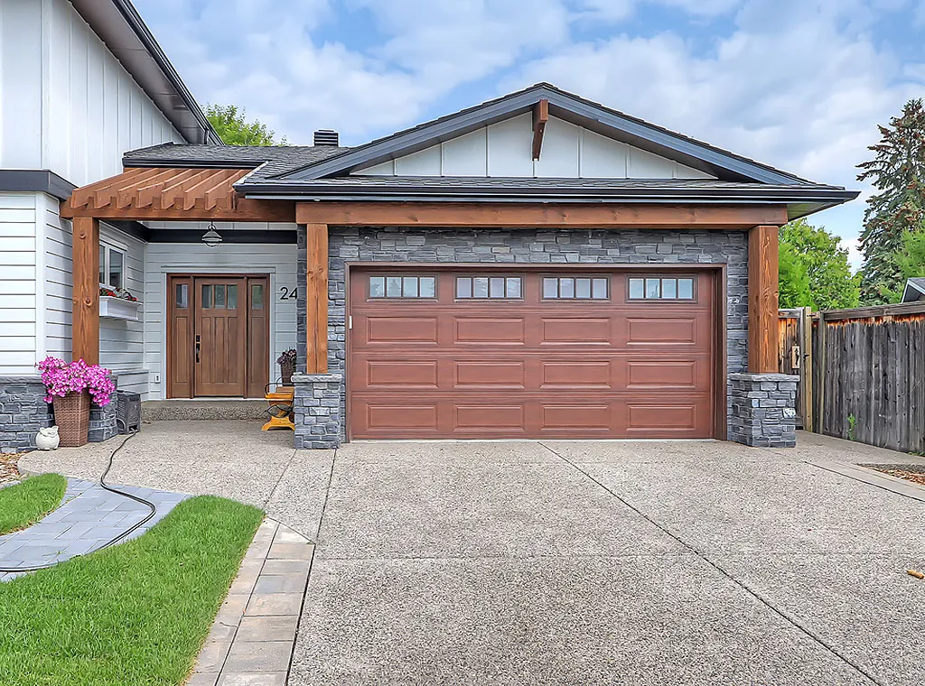 Modern Calgary home with wood-accented garage, stone siding, and a stylish front entry.